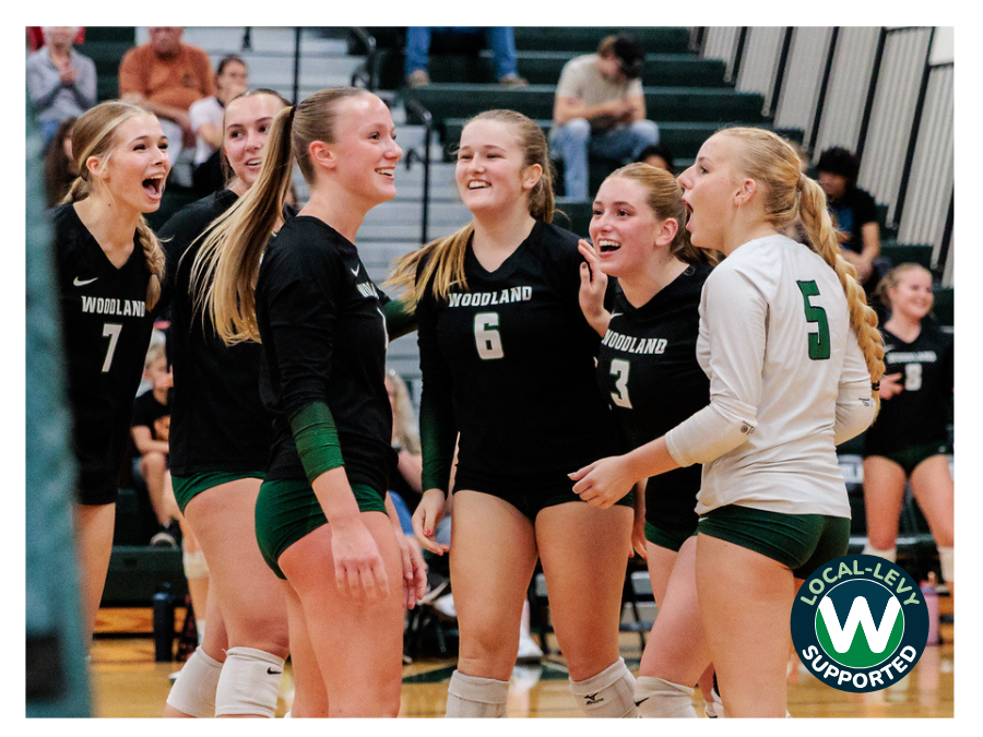Volleyball players grouped together and smiling